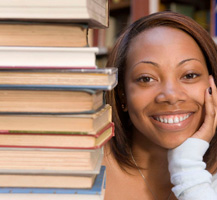 Young woman next to a stack of books